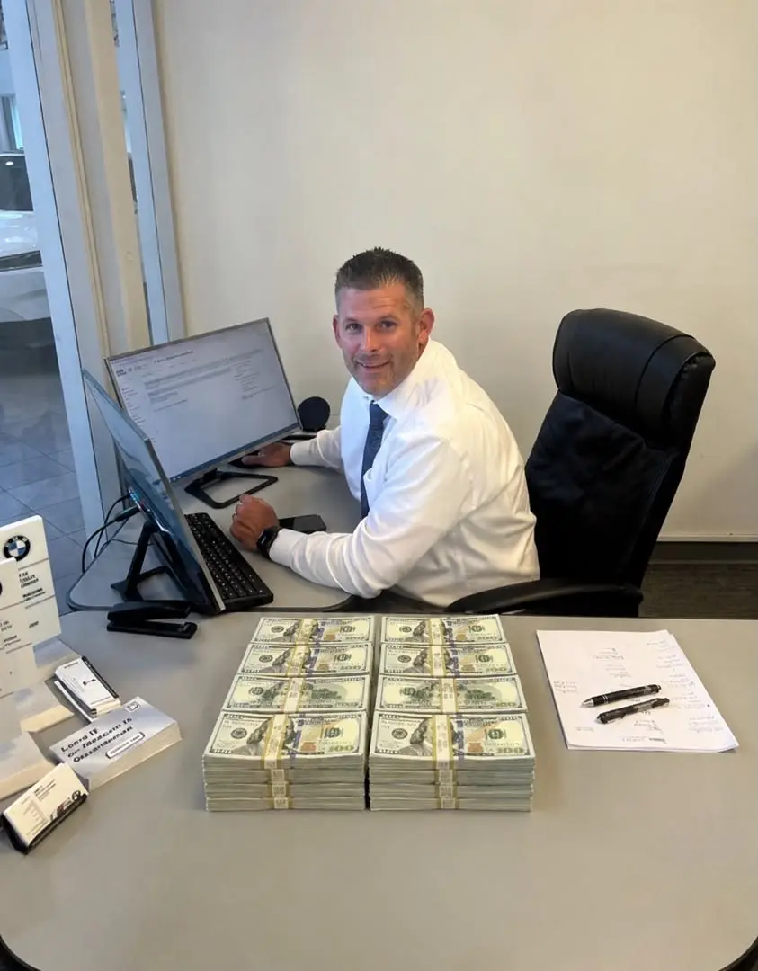 A businessman at his desk beside neat stacks of banknotes